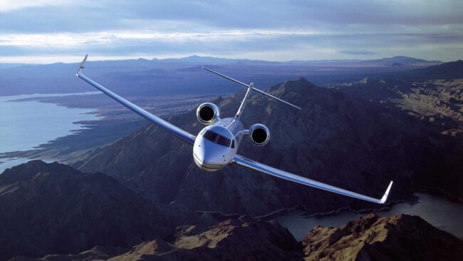 Corporate aircraft flying over mountain